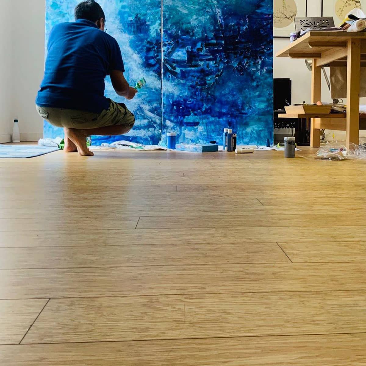 Western and asian art. Chinese artist Yan Bei painting in his studio
